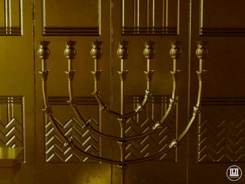 Gegenüber dem Schaubrottisch stand der Leuchter aus massivem Gold. Er hatte einen Mittelarm und drei Arme, die links und rechts davon ausgingen. Er war mit der Knospe, Blüte und Frucht des Mandelbaums verziert. Die sieben Arme trugen die brennenden Lampen, die jede Nacht, vom Abend bis zum Morgen, ununterbrochen brannten (3. Mose 24,2-3). – Folie 8