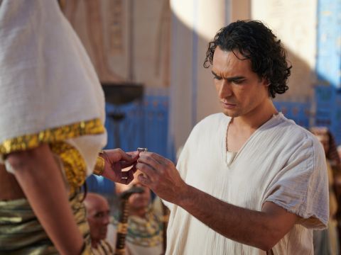 Da fragte der Pharao seine Beamten: „Können wir einen Mann wie Josef finden, einen, in dem der Geist Gottes wohnt?“ Der Pharao sagte zu Josef: „Da Gott dich all dies wissen ließ, gibt es niemanden, der so weise und einsichtig ist wie du. Du wirst meinen Haushalt leiten, und mein ganzes Volk wird sich deinen Befehlen unterwerfen. Nur ich, der König, werde größer sein als du.“<br/>Dann nahm der Pharao seinen Siegelring von seiner Hand und steckte ihn Josef an. – Folie 11