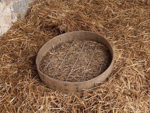 Da das Getreide noch Bestandteile aus Spreu, Unkraut oder kleinen Steinen enthielt, wurde es anschließend durch ein Sieb gesiebt. – Folie 26